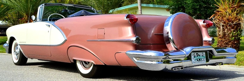 rear view of a 1956 Oldsmobile Starfire with the convertible top down and fitted with a continental kit