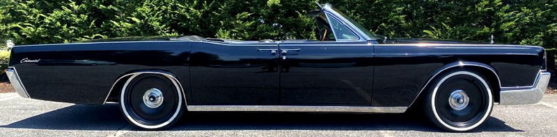 side view of a 67 Lincoln Continental convertible with the top down.