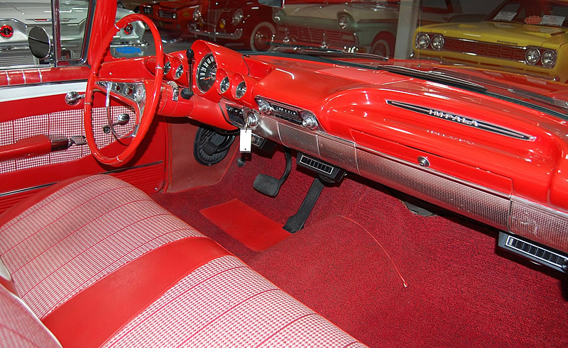 red / white interior of a 60 Chevy Impala convertible showing the dash