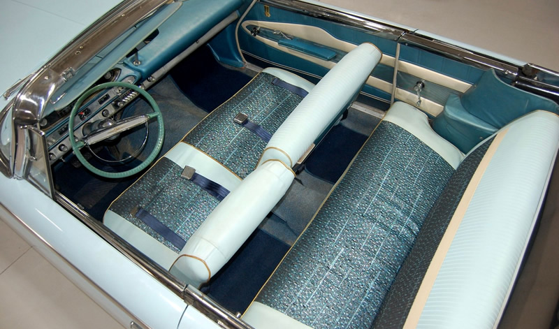 rich fabric and vinyl interior of a '60 Plymouth Fury convertible with the top down